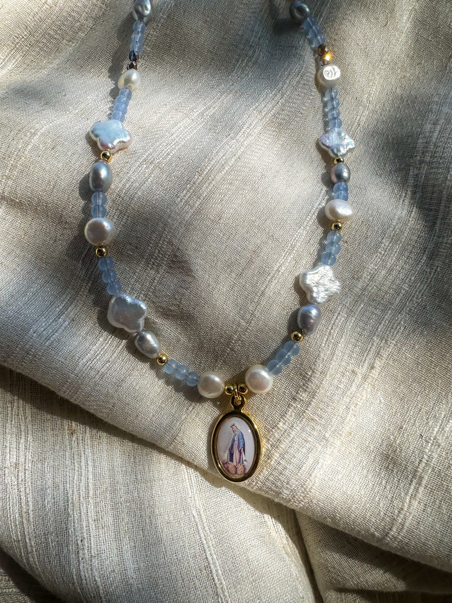 Beaded necklace featuring fresh water pearls and glass beads. Virgin Mary pendant