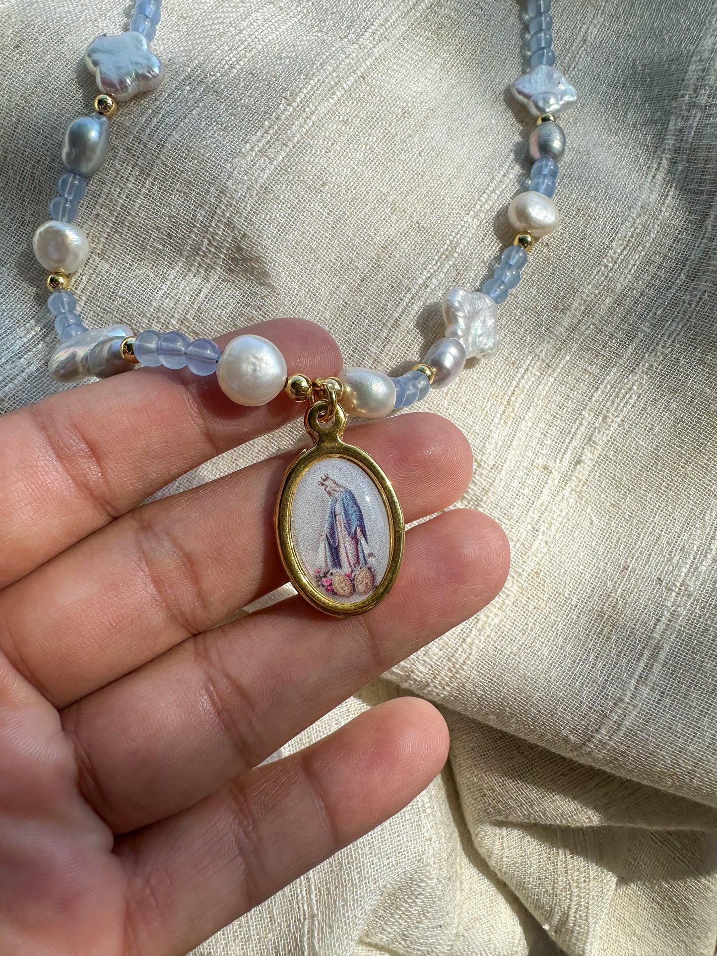 Beaded necklace featuring fresh water pearls and glass beads. Virgin Mary pendant