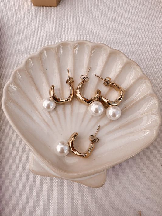 Pearl stud earrings on ceramic shell plate 